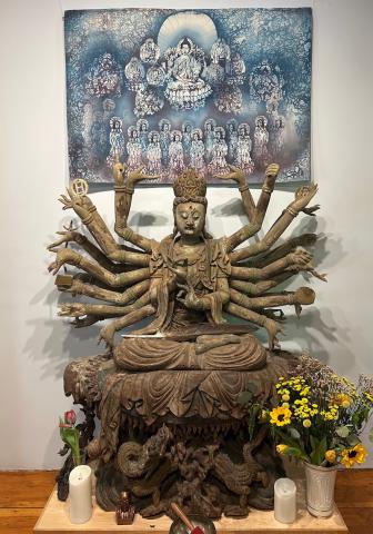 An image of a Kuan Yin shrine with flowers