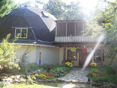 sunlight through trees and Aryaloka's front entrance